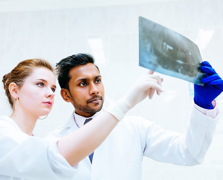 multiracial-dental-team-checking-teeth-x-ray-of-pa-2022-01-19-19-05-54-utc.jpg