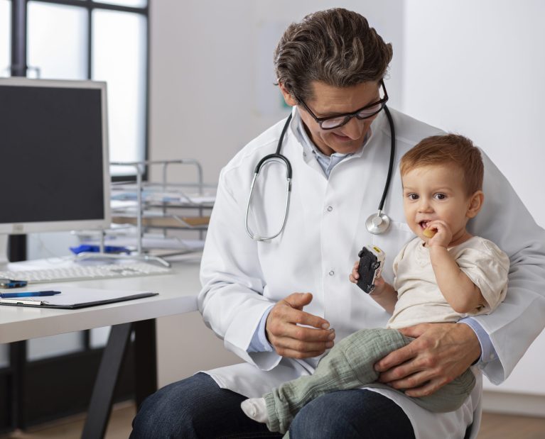 pediatrician-holding-toddler-consulation-scaled.jpg